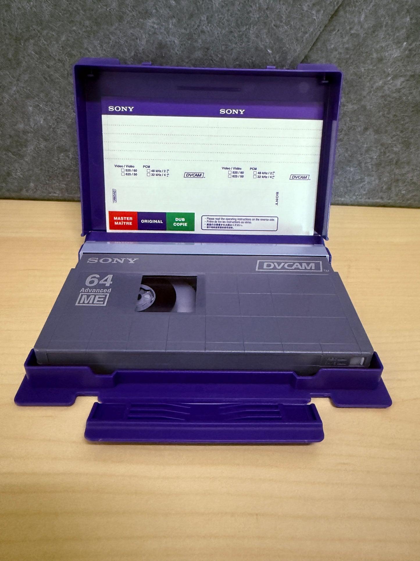 Vintage Sony cassette tape with open purple case on a wooden surface