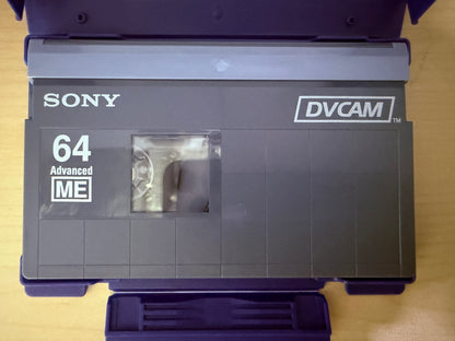 Sony DVCAM tape with '64 Advanced ME' label on a wooden surface
